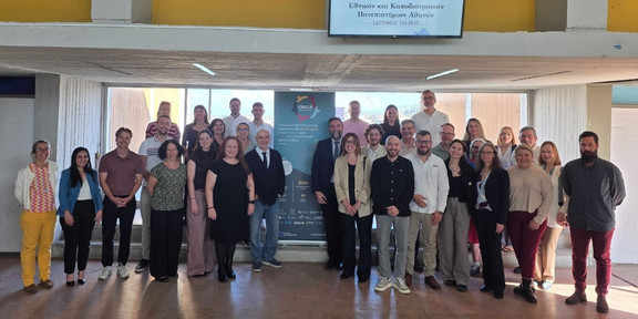 Teilnehmende des CIRCLE-Kick-Offs in Athen neben einem Roll-Up mit Informationen zu dem Projektstart 