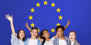 Jugend in Europa Fünf Jugendliche lächeln in die Kamera vor der europäischen Flagge