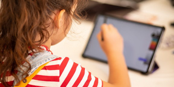Grundschulkind arbeitet am Tablet