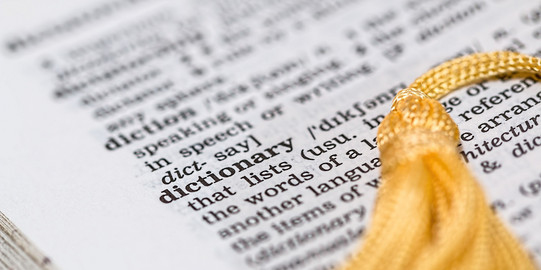 An open page of an english dictionary with a yellow bookmark.