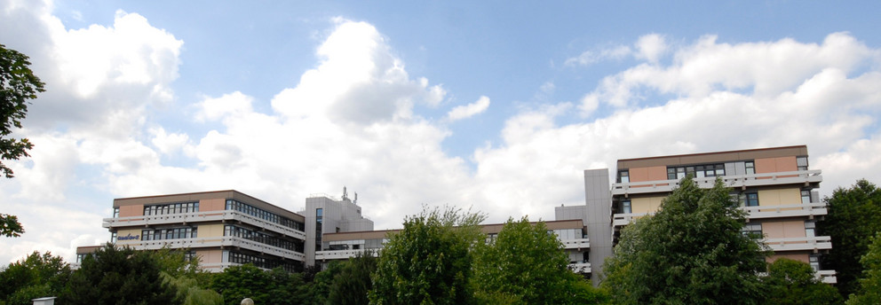 Emil-Figge-Straße 50 mit Wolken und grünen Bäumen im Hintergrund 